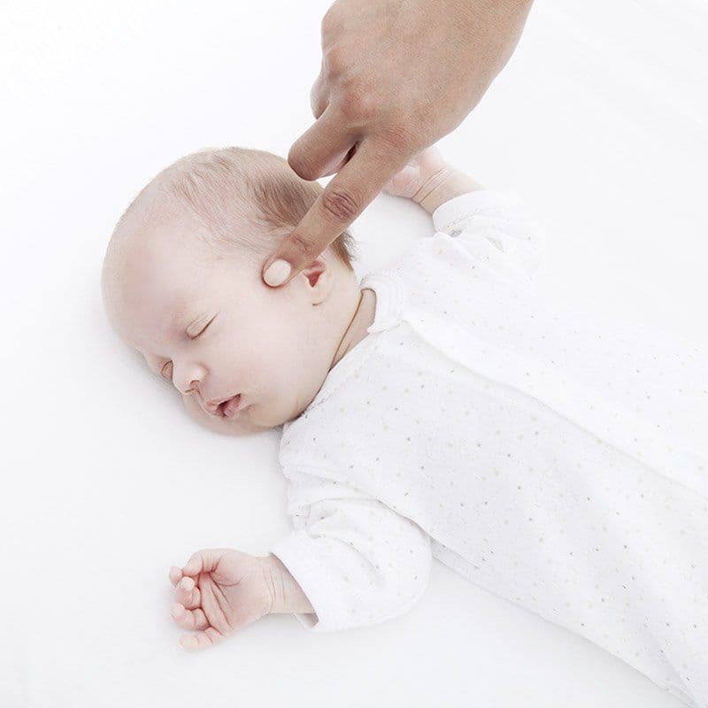 Woman pointing her finger at a baby's head
